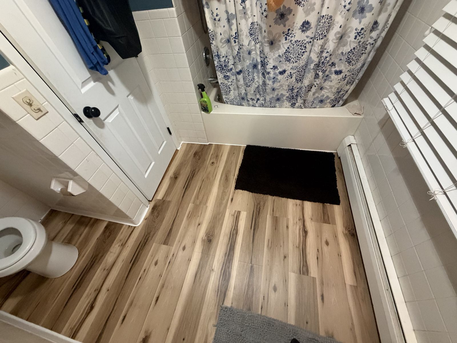 New vinyl plank floor around a tub and toilet