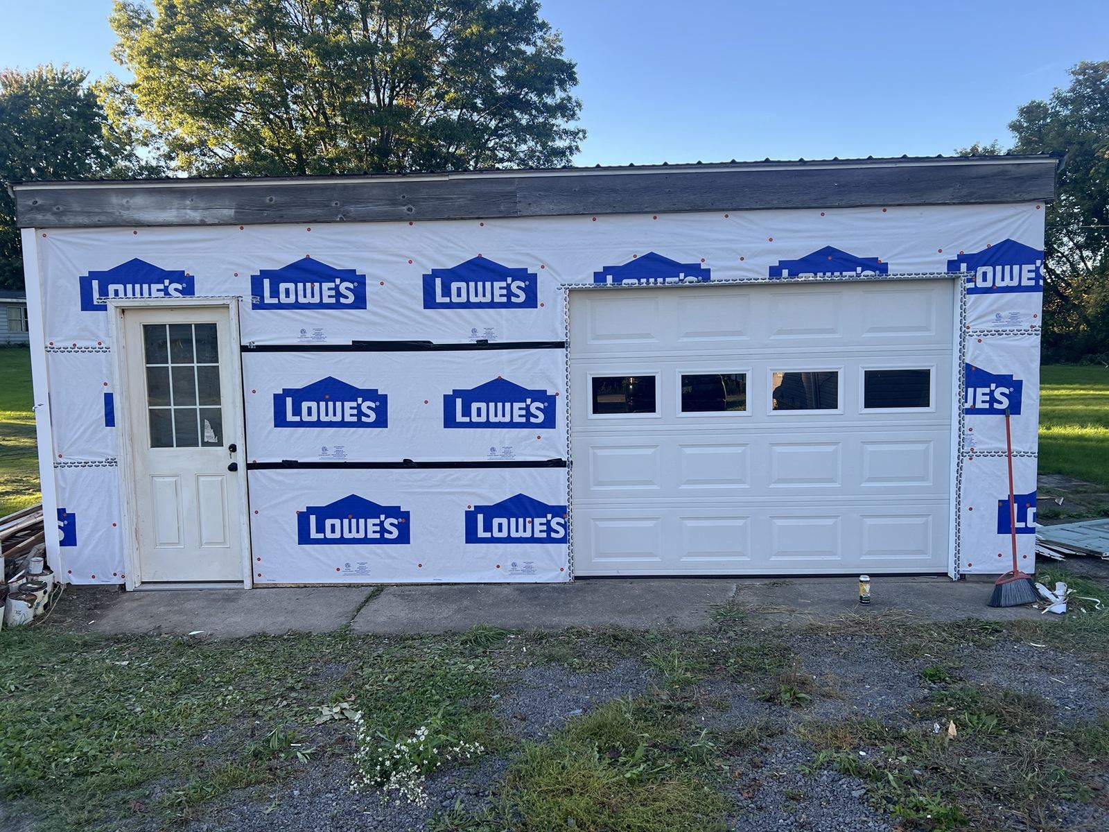 Same garage with both new doors installed and house wrap on, ready for siding